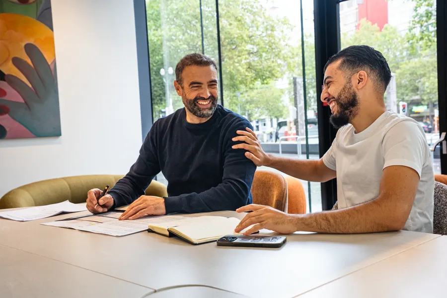 Deux collègues riant ensemble à leur bureau