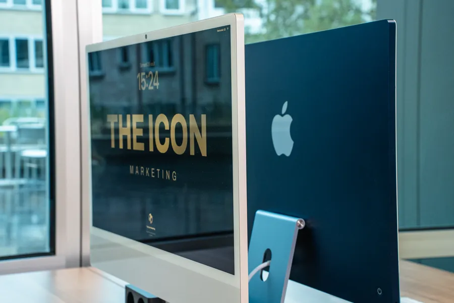 Écran d'ordinateur affichant le logo THE ICON, à côté d'un iMac