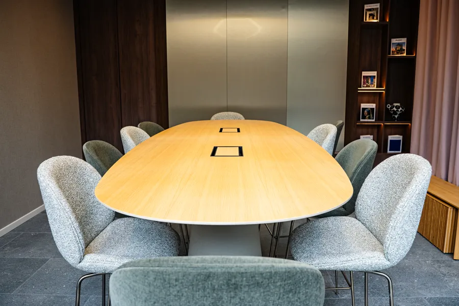 Salle de réunion avec table ovale et chaises grises