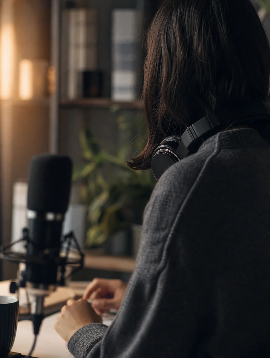 Enregistrement d'un podcast, casque audio autour du cou, devant un micro sur pied
